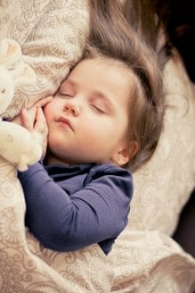 toddler asleep in their bed