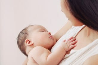 Woman holding sleeping baby