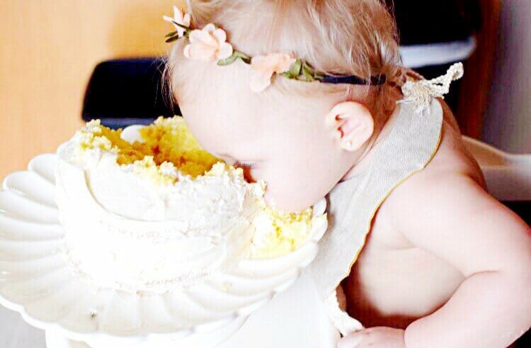 Baby with face in her smash cake