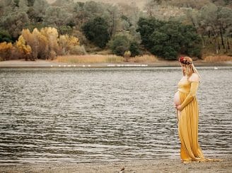 looking down at belly by the water maternity photo