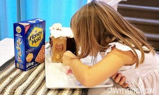 girl looking in a house made from Honey Maid Crackers