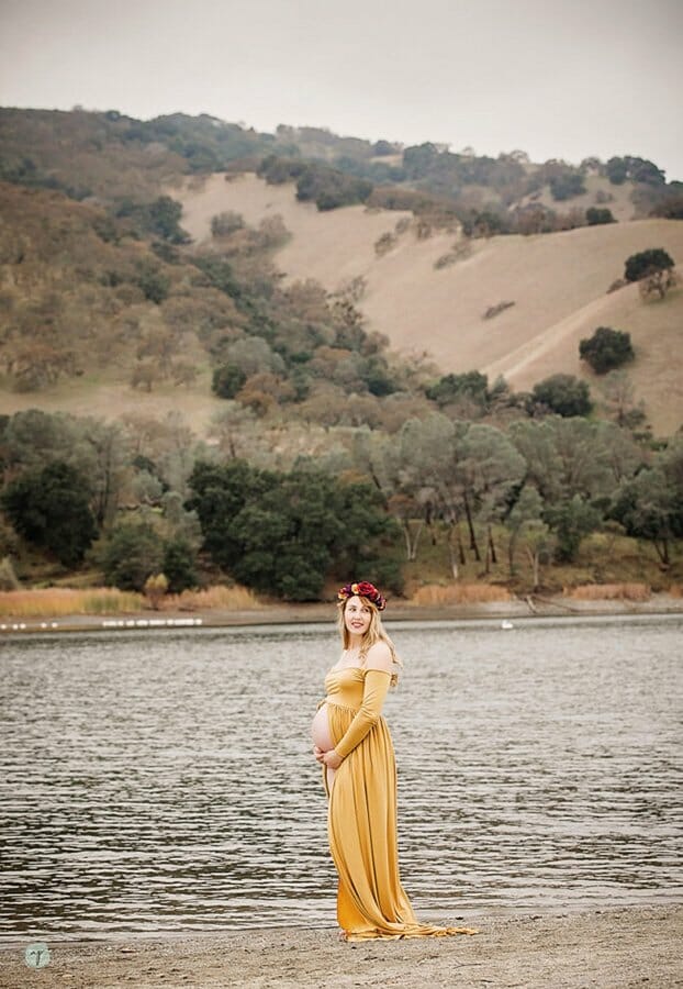 maternity photo of mom standing by water