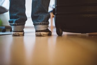 child next to their luggage