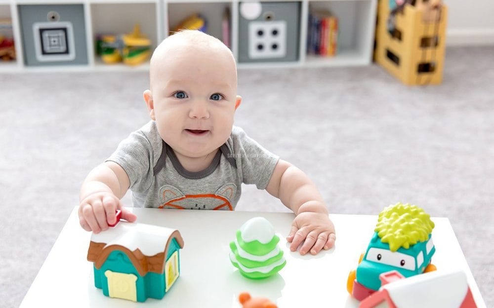 baby in fox onesie playing with toys