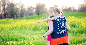 mom and child standing in a field of mustard