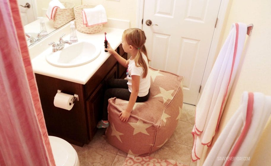 S sitting on pouf in coral bathroom