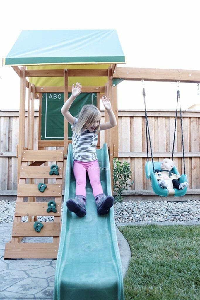 sliding down slide next to little bro