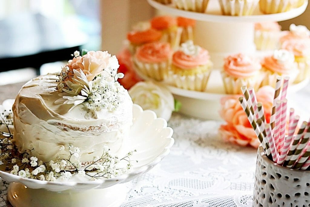 floral first birthday sweets table with a smash cake and cupcake tier.